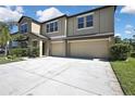 Two-story home features a three-car garage, neutral stucco exterior, and well-maintained landscaping at 35965 Saddle Palm Way, Zephyrhills, FL 33541