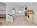 Bright living room with light wood flooring, stone fireplace, and a ceiling fan for added comfort at 4405 W Fair Oaks Ave # 9, Tampa, FL 33611