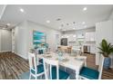 Open concept dining room featuring a white wood table with seating for six and a view of the kitchen at 4559 Mitcher Rd, New Port Richey, FL 34652