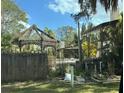 Exterior features a lattice gazebo and privacy fence in lush, overgrown backyard at 4628 Cypress S Way, St Petersburg, FL 33705
