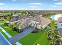 Beautiful home with tile roof, three-car garage, lush landscaping, and water view at 4824 Benito Ct, Bradenton, FL 34211