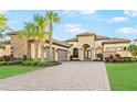 Beautiful home with stone accents, lush landscaping, three-car garage, and arched entry at 4824 Benito Ct, Bradenton, FL 34211