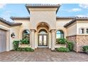 Close up view of a home's facade, with a decorative front door, architectural pillars, and manicured greenery at 4824 Benito Ct, Bradenton, FL 34211