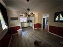 Open dining area showcasing hardwood floors and an adjacent kitchen with white cabinetry at 5808 N 17Th St, Tampa, FL 33610