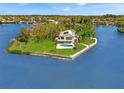 Gorgeous aerial view of waterfront estate with lush lawn, private pool, mature trees, and serene waterfront setting at 7049 Peninsular Dr, New Port Richey, FL 34652