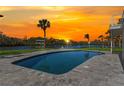 Enjoy sunset views from the private pool with lovely pool deck and tropical landscaping at 7049 Peninsular Dr, New Port Richey, FL 34652