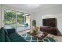 Cozy living room featuring natural light, hardwood flooring, and a sliding glass door with access to the backyard at 7804 N Whittier St, Tampa, FL 33617