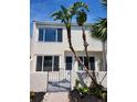 Charming two-story home with stucco facade and tropical landscaping. Updated windows and entry gate at 8707 Sailmaker Ct, Tampa, FL 33615