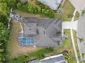 Aerial view of the backyard with a screened-in pool, patio and fire pit area at 8833 Bel Meadow Way, Trinity, FL 34655