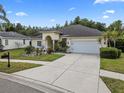 Inviting single-story home with lovely landscaping, a spacious driveway, and attached two car garage at 8833 Bel Meadow Way, Trinity, FL 34655