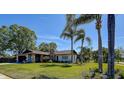 Well-maintained home featuring mature palm trees and a stone chimney at 10 Arbor Ln, Oldsmar, FL 34677