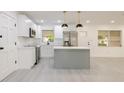 Bright kitchen boasts white cabinetry, stainless steel appliances, a center island, and stylish pendant lighting at 1032 26Th S Ave, St Petersburg, FL 33705