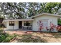 Quaint single-story home featuring a covered porch with sitting area and decorative window shutters at 10514 52Nd N Ave, St Petersburg, FL 33708