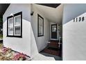 Close-up of the home's entrance with a tiled walkway, contrasted by the white exterior and dark trim details at 1138 Howard St, Clearwater, FL 33756