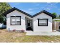 Inviting single-story home showcasing a clean white exterior, black window trim, and a welcoming front walkway at 1138 Howard St, Clearwater, FL 33756