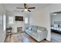 Bright living room features a decorative fireplace, modern ceiling fan, and stylish wood-look flooring at 1138 Howard St, Clearwater, FL 33756