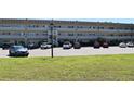 View of condo building with a green lawn in the foreground and parking area at 2284 Philippine Dr # 41, Clearwater, FL 33763