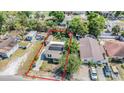 Aerial view of a charming single-Gathering home with solar panels, shed and partially fenced yard at 2414 W State St, Tampa, FL 33609