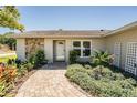 Charming home featuring a decorative stone exterior and manicured landscaping at 2755 Merlin Way, Clearwater, FL 33761