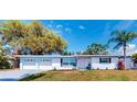 Inviting single-story home with a well-manicured lawn, two-car garage, and mature landscaping at 2760 Kumquat Dr, Clearwater, FL 33759