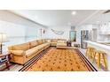 Bright living room featuring a large sectional sofa, stylish rug, and stainless steel appliances in the kitchen at 2760 Kumquat Dr, Clearwater, FL 33759