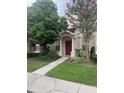 Inviting home exterior with a red door, well-maintained landscaping, and a clear walkway leading to the entrance at 30132 Wellesley Way, Wesley Chapel, FL 33543