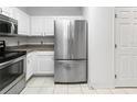 Bright kitchen with stainless steel refrigerator, sleek appliances, and white cabinetry at 30132 Wellesley Way, Wesley Chapel, FL 33543