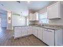A well-designed kitchen offers granite countertops, white cabinets, and a view into the adjacent living area at 3138 Clover Blossom Cir, Land O Lakes, FL 34638