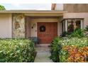 Inviting front entrance with double doors, stone accents, and lush greenery at 3388 Tarpon Woods Blvd, Palm Harbor, FL 34685