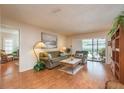 Cozy living room with wood flooring, a sliding glass door, and comfortable furnishings at 3388 Tarpon Woods Blvd, Palm Harbor, FL 34685