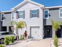 Modern two-story townhome with a garage, complemented by lush landscaping and an inviting facade at 34355 Sorrel Mint Dr, Wesley Chapel, FL 33543