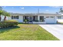 Charming single-story home featuring a well-manicured lawn, screened entryway, and attached one-car garage at 3808 97Th N Ave, Pinellas Park, FL 33782