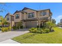 Attractive two-story home featuring a two-car garage, lovely landscaping, and a paver driveway at 4600 Lagona Ln, Wesley Chapel, FL 33543