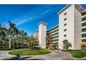 Building exterior featuring lush landscaping, roundabout entry, and tile roofing at 4801 Osprey S Dr # 508, St Petersburg, FL 33711