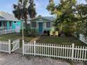 Charming cottage home with a well-manicured lawn and white picket fence, creating a welcoming curb appeal at 5314 21St S Ave, Gulfport, FL 33707