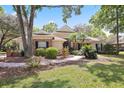 Attractive front yard with brick walkway, mature trees, and lush landscaping enhances this welcoming home at 6109 Kingbird Manor Dr, Lithia, FL 33547