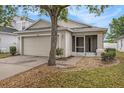 Traditional single-Gathering home featuring a well-manicured lawn and a two-car garage at 7924 Carriage Pointe Dr, Gibsonton, FL 33534