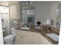 Bathroom featuring double sinks with granite countertop, framed mirror, and a shower with seating at 8609 Thimbleberry Ln, Tampa, FL 33635