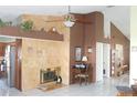 Spacious living room featuring a fireplace, ceiling fan, and seamless access to an adjacent kitchen at 8609 Thimbleberry Ln, Tampa, FL 33635