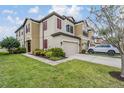 Attractive two-story townhome with two-car garage, lush lawn and colorful landscaping at 11602 Crowned Sparrow Ln, Tampa, FL 33626
