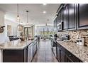 Modern kitchen featuring dark cabinetry, granite countertops, stainless steel appliances at 11602 Crowned Sparrow Ln, Tampa, FL 33626