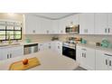Modern kitchen featuring sleek white cabinets, stainless steel appliances, and quartz countertops at 12006 Glenshire Dr, Riverview, FL 33579
