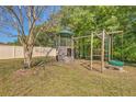 Backyard playground featuring climbing wall, swings, covered tower and monkey bars provides outdoor entertainment at 1218 Halapa Way, Trinity, FL 34655