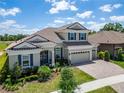 Aerial view of a beautiful two-story home with a tile roof, three-car garage, and lush landscaping at 14239 Swiss Bridge Dr, Riverview, FL 33579