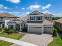 An elevated shot of a two-story home with a three-car garage, tile roof and landscaped front yard at 14239 Swiss Bridge Dr, Riverview, FL 33579