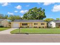 Inviting single-story home boasts a well-manicured lawn and tidy landscaping, enhancing its curb appeal at 145 Avon Dr, Safety Harbor, FL 34695