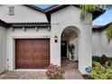 Arched entryway to a home featuring a decorative garage door and a well-manicured front yard at 16927 April Plush Dr, Wimauma, FL 33598