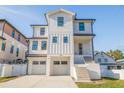 Modern white two-story home featuring a dual-car garage and elevated entry with sleek architectural details at 1745 Massachusetts Ne Ave, St Petersburg, FL 33703