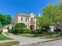 Elegant two-story home boasting a landscaped front yard, complemented by mature trees and a charming architectural design at 2927 W Bayshore Ct, Tampa, FL 33611