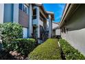 Charming townhome entrance with stairs leading to the upper level, surrounded by lush greenery and modern architectural details at 3024 Landmark Blvd # 607, Palm Harbor, FL 34684